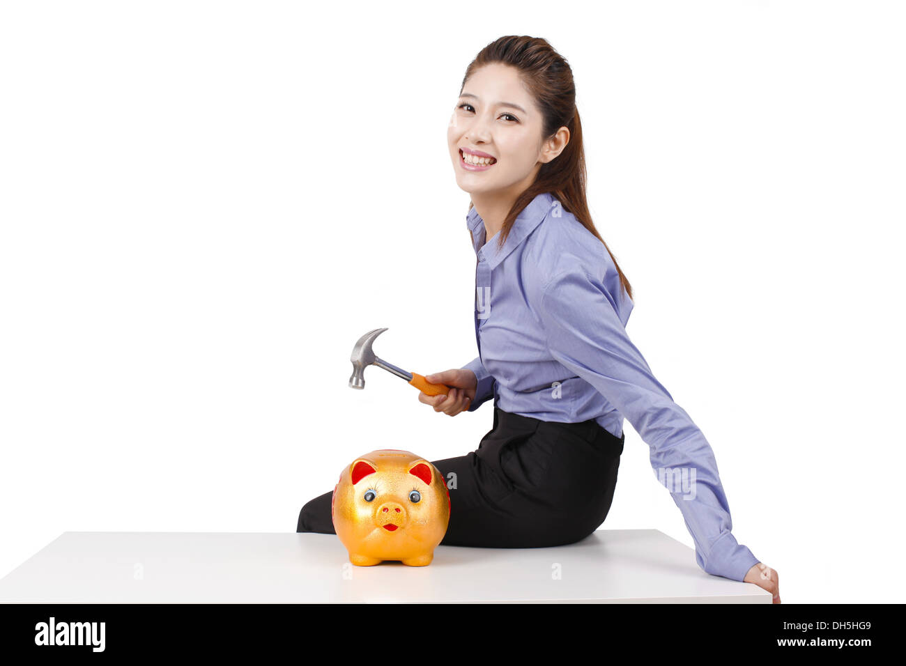 Businesswoman using hammer to smash open a piggy bank Stock Photo - Alamy