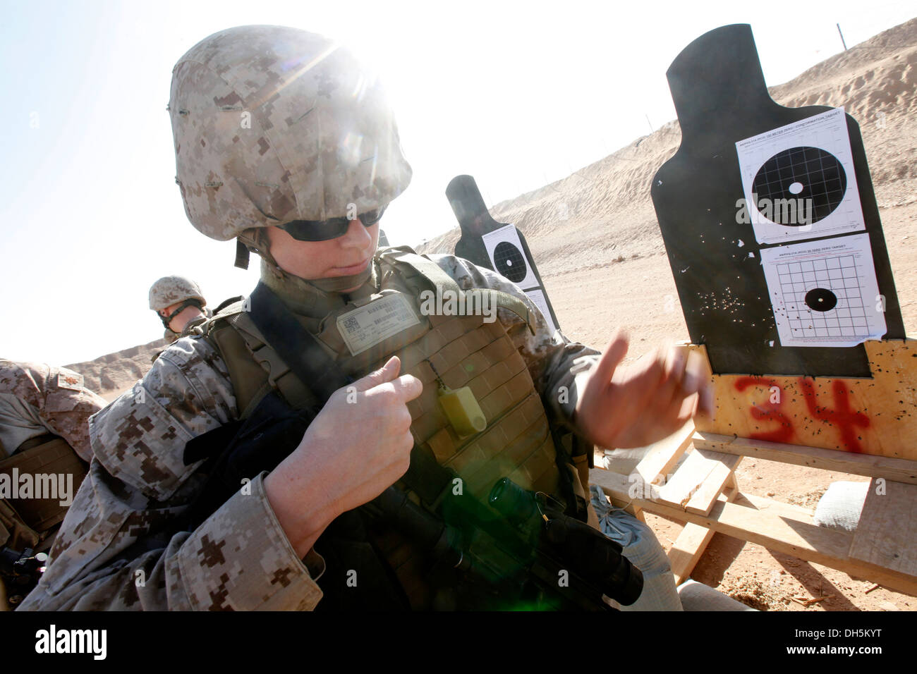 U.S. Navy Hospitalman Lindsay L. Robinson, a corpsman with Headquarters, 2nd Marine Aircraft Wing (Forward), makes adjustments to her M4 service rifle during a Battle Sight Zero (BZO) range at Camp Leatherneck, Helmand province, Afghanistan, Oct. 25, 2013 Stock Photo