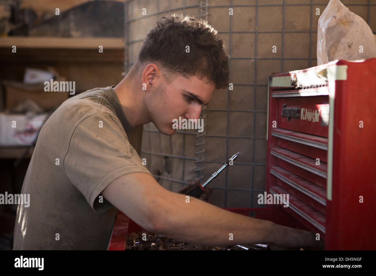 U.S. Marine Corps Lance Cpl. Alex Thomason, a motor transport mechanic with Lima Company, 3rd Battalion, 7th Marine Regiment, selects the proper tool to repair a M1114 High Mobility Multipurpose Wheeled Vehicle at Forward Operating Base (FOB) Zeebrugge, K Stock Photo