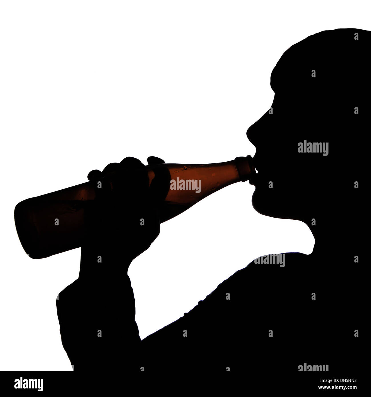 silhouette of a person drinking a bottle of beer Stock Photo