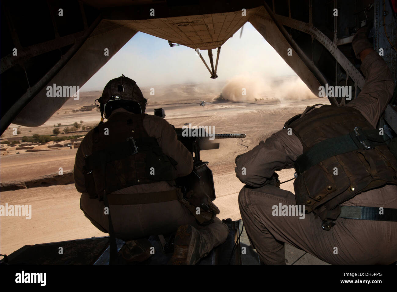 U.S. Marines Cpl. Ryan L. Avery, left, a crew chief, and Lance Cpl. Michael J. McGrath, a CH-53E Super Stallion mechanic, both with Marine Heavy Helicopter Squadron 462 (HMH-462), provide aerial security over Gurjat Village, Helmand province, Afghanistan, Stock Photo