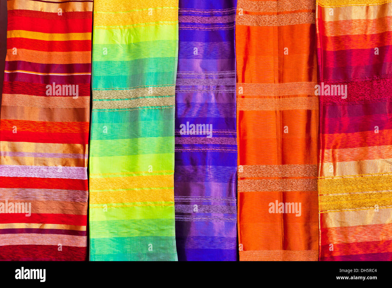 Brightly coloured fabrics are offered for sale in the souk, bazaar area, Medina, Fez, Morocco, Africa Stock Photo