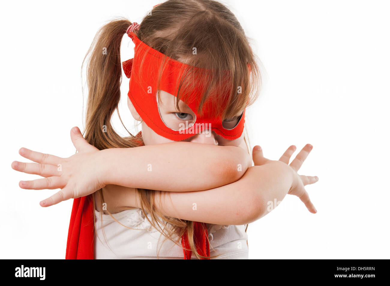 Superhero little girl in a red raincoat and a mask Stock Photo