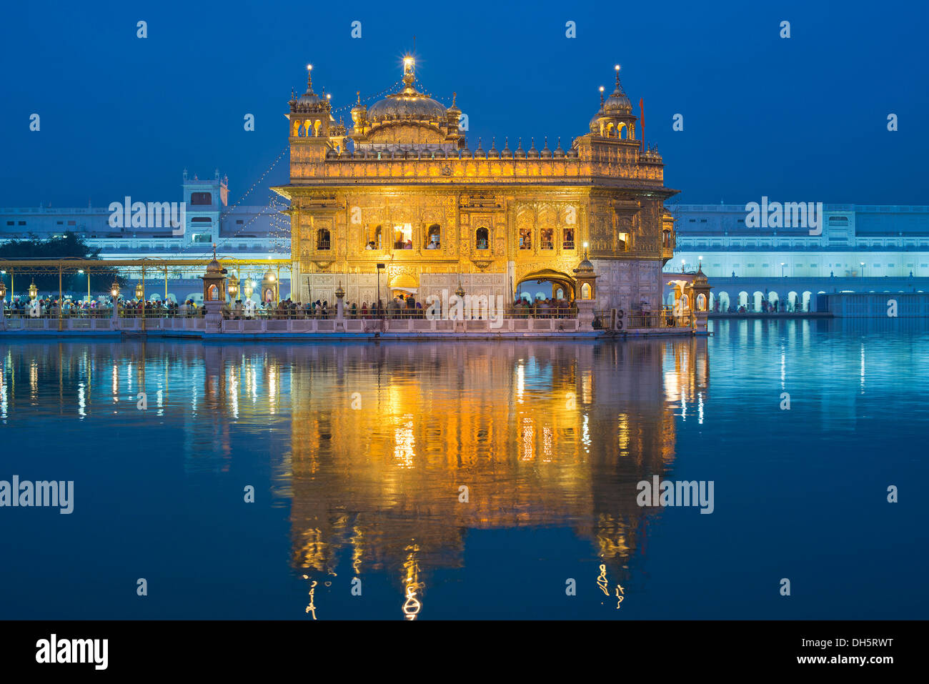 The Harmandir Sahib or Darbar Sahib, Golden Temple, the main shrine of the Sikhs, with the holy Amrit Sagar lake at dusk Stock Photo