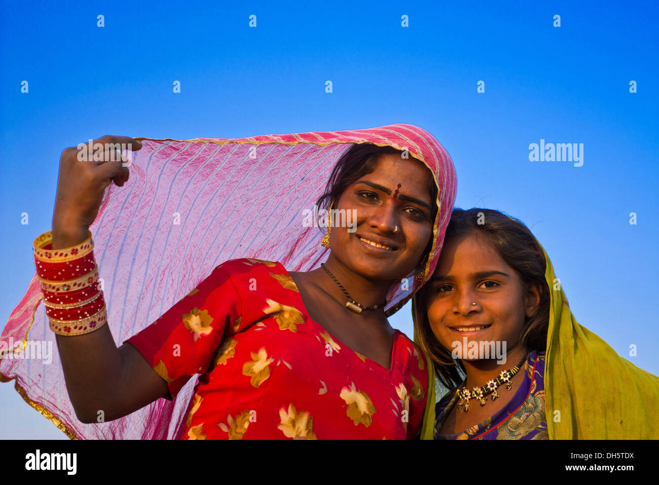 Two friendly Indian girls with colorful head scarves and jewellery, portrait, Pushkar, Rajasthan, India Stock Photo