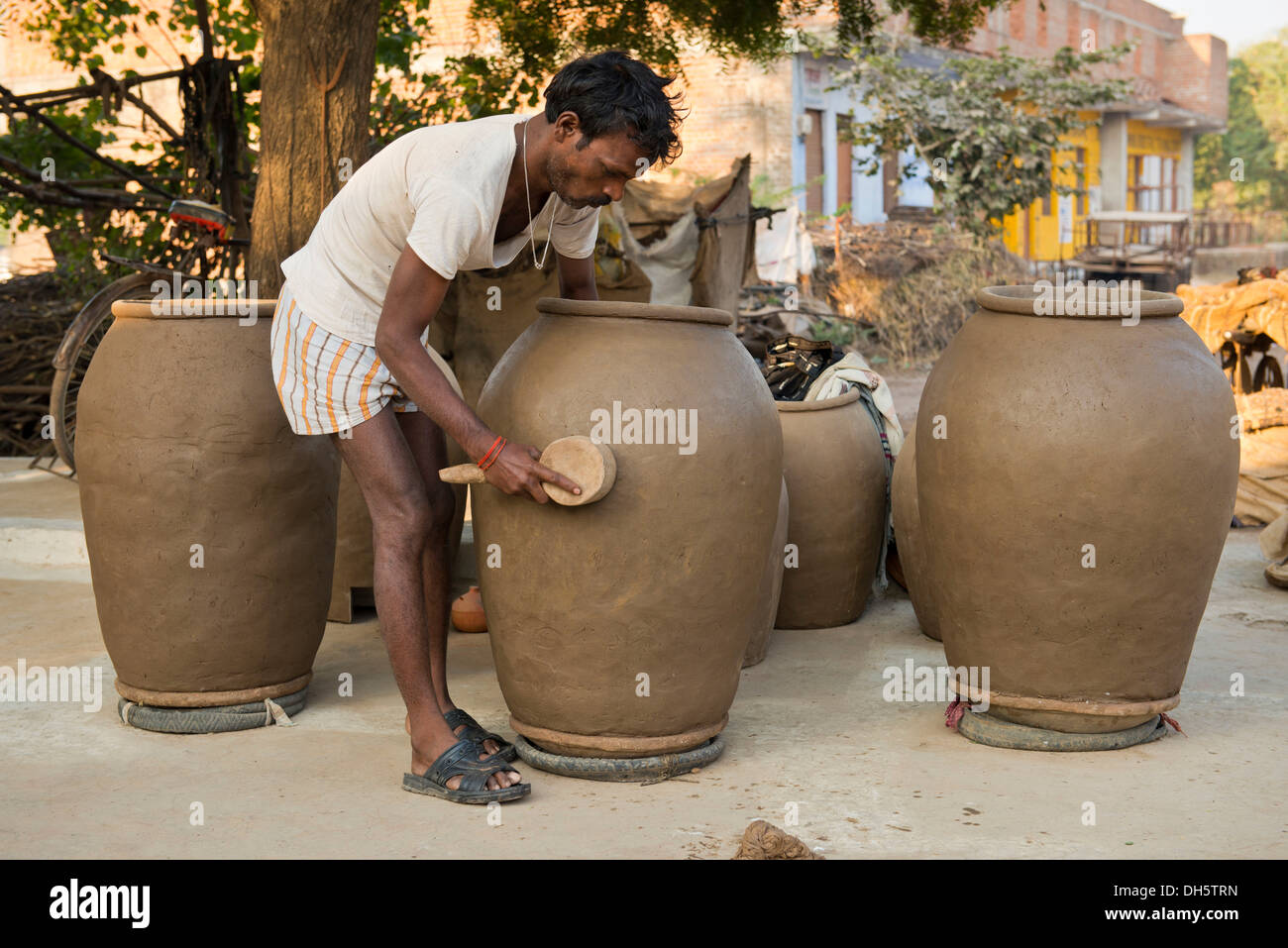 Indian man forming huge clay pots with a wooden tool, Khajuraho, Madhya Pradesh, India Stock Photo