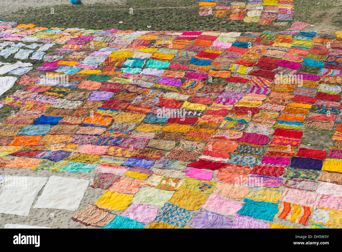 Colourful saris laying to dry after washing on a sandbank on the banks of the Yamuna River, Yamuna, Agra, Uttar Pradesh, India Stock Photo