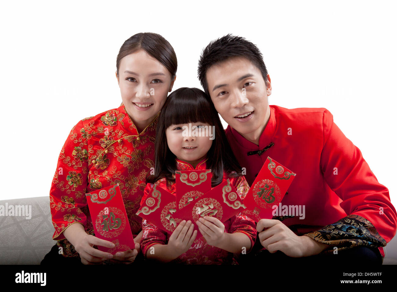 Family of three wearing costume and red envelope Stock Photo