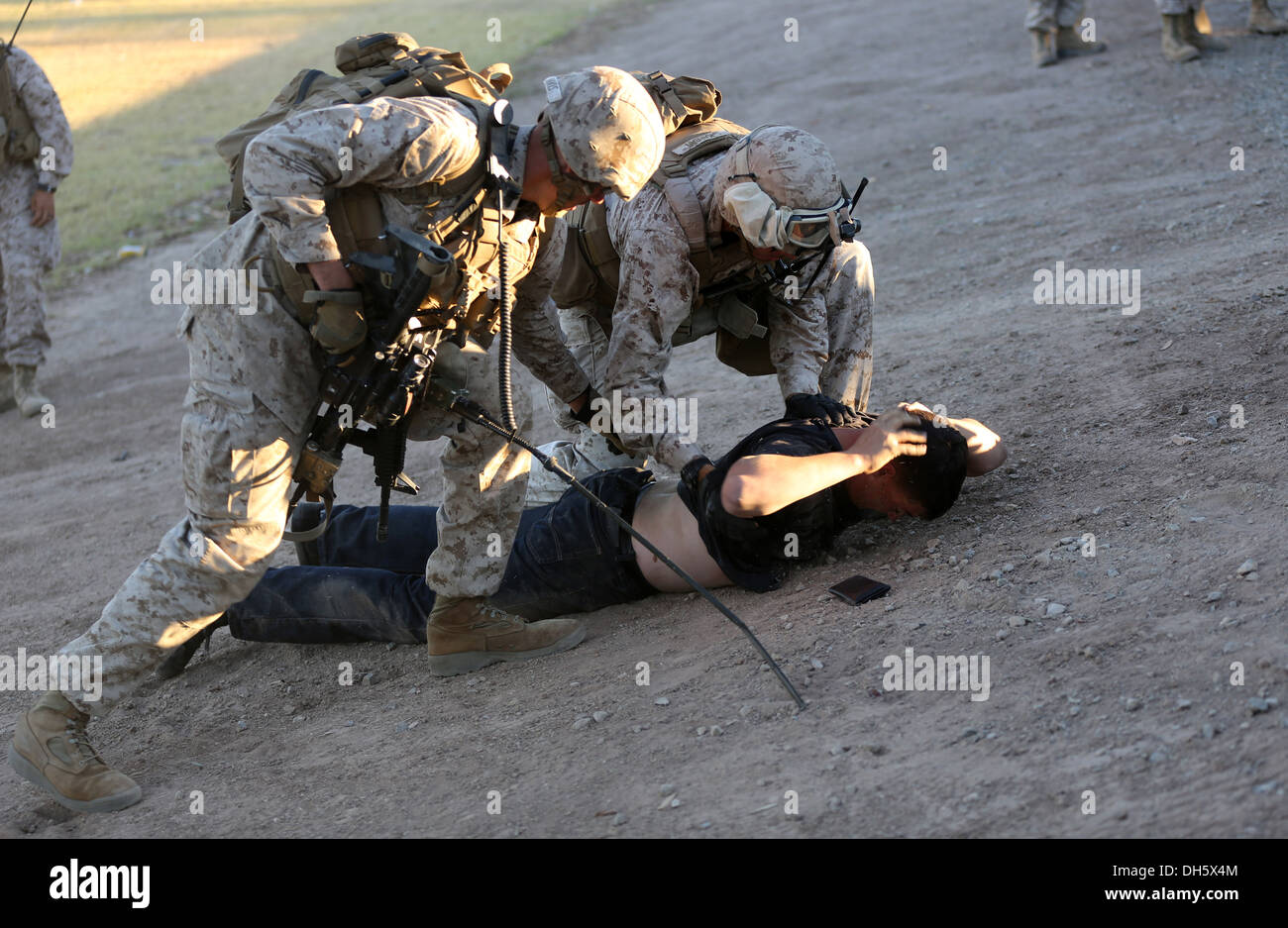 MARINE CORPS AIR STATION YUMA, Ariz. – Marines with Bravo Company, 1st Battalion, 7th Marine Regiment, detain a role-player during a noncombatant evacuation operation training exercise here, Oct. 18, 2013. The Bravo Co. Marines and corpsmen treated ill or Stock Photo