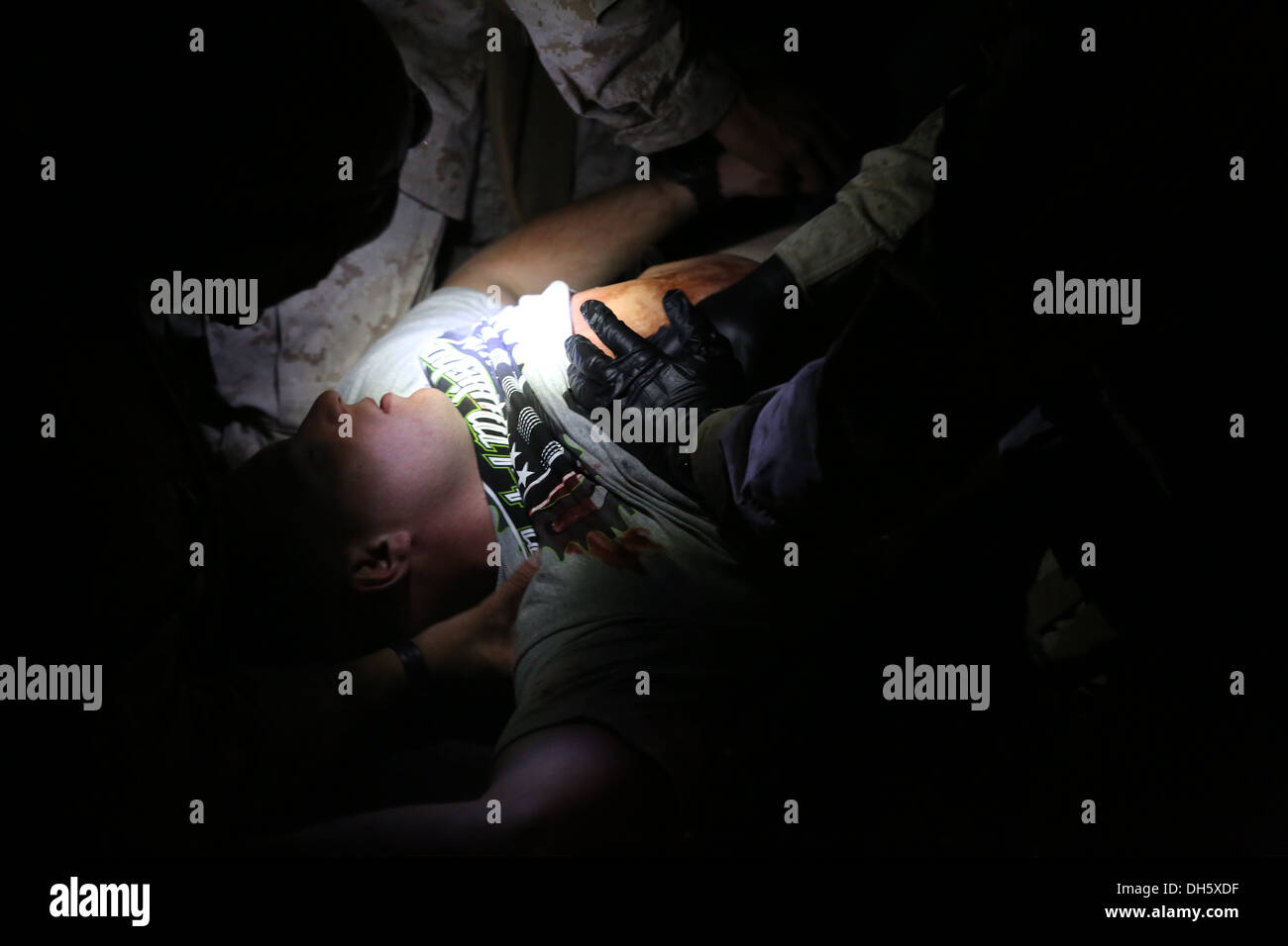 MARINE CORPS AIR STATION YUMA, Ariz. – Corpsmen with 1st Battalion, 7th Marine Regiment, treat a simulated casualty during a noncombatant evacuation operation training exercise here, Oct. 18, 2013. Corpsmen treated ill role-players during the day and trea Stock Photo