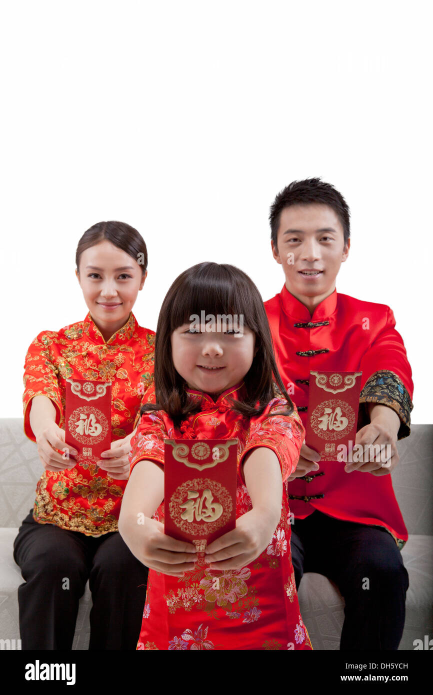 Family of three wearing costume and red envelope Stock Photo