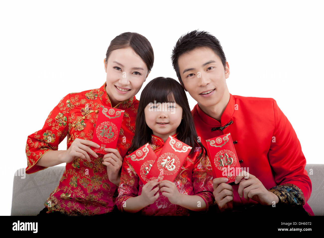 Family of three wearing costume and red envelope Stock Photo