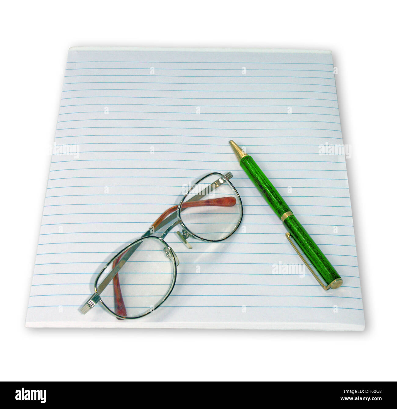 Ruled notepad with reading glasses and bright green ballpoint pen on plain white background Stock Photo