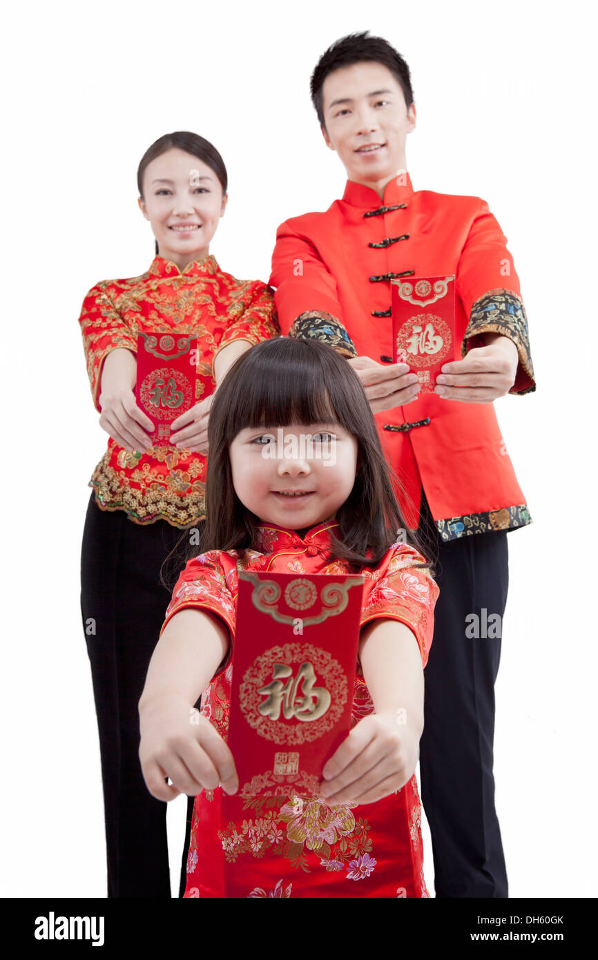 Family of three wearing costume and red envelope Stock Photo