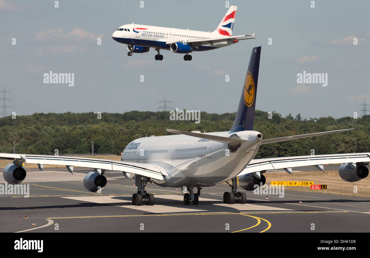Lufthansa Airbus A340-300 waiting for incoming British Airways Airbus A320 to land at Dusseldorf International airport Germany Stock Photo