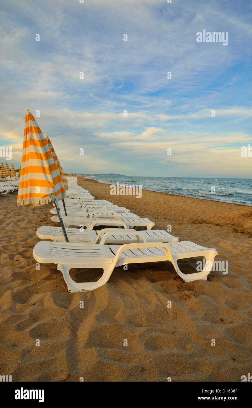 Sun Loungers on the beach at sundown on the Mediterranean at Cap d'Agde, Hérault, Languedoc-Roussillon, France. Stock Photo