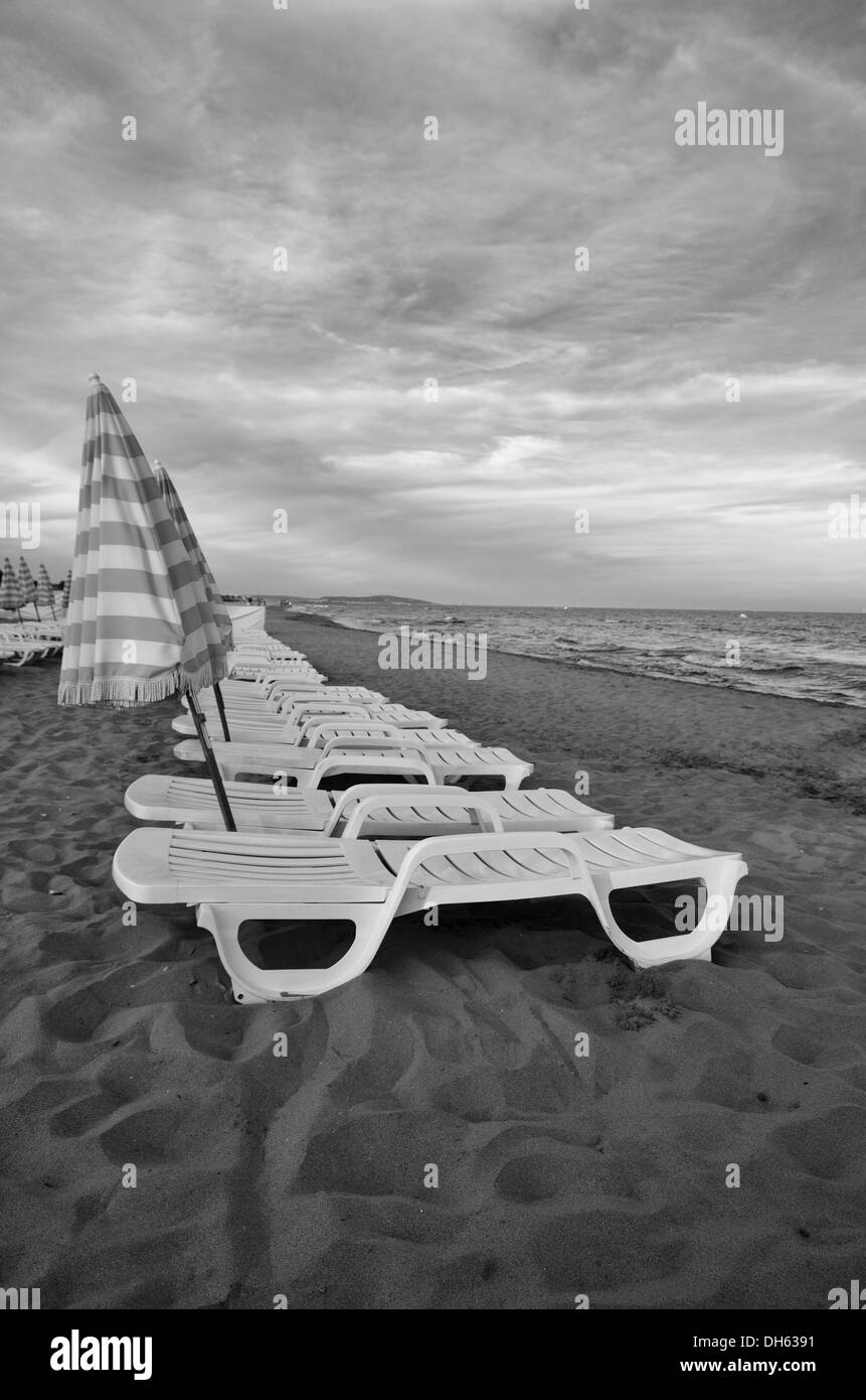 Sun Loungers on the beach at sundown on the Mediterranean at Cap d'Agde, Hérault, Languedoc-Roussillon, France. Stock Photo
