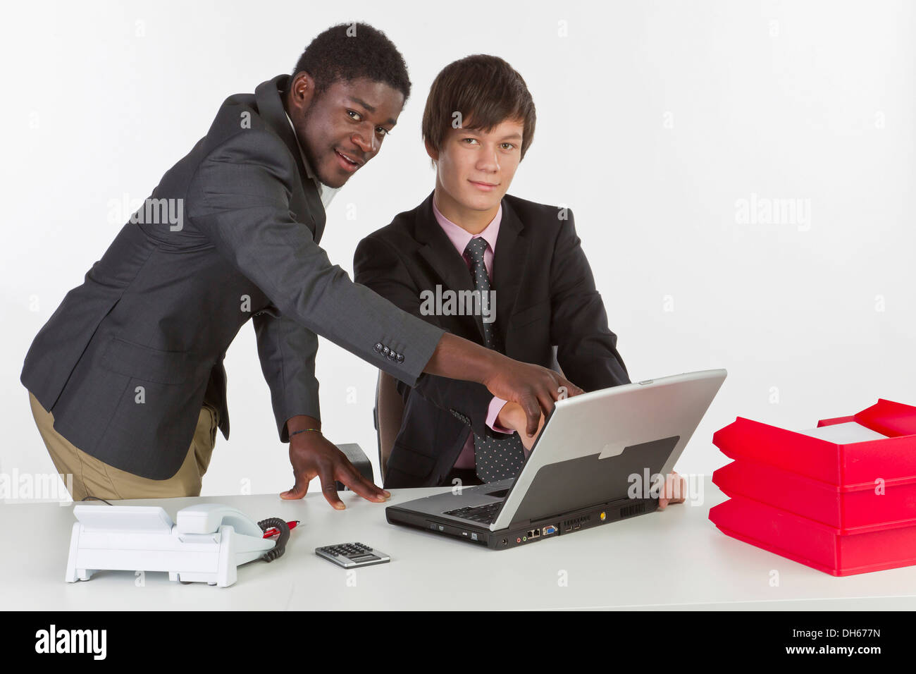 Two young businessmen of different races working on a laptop Stock Photo