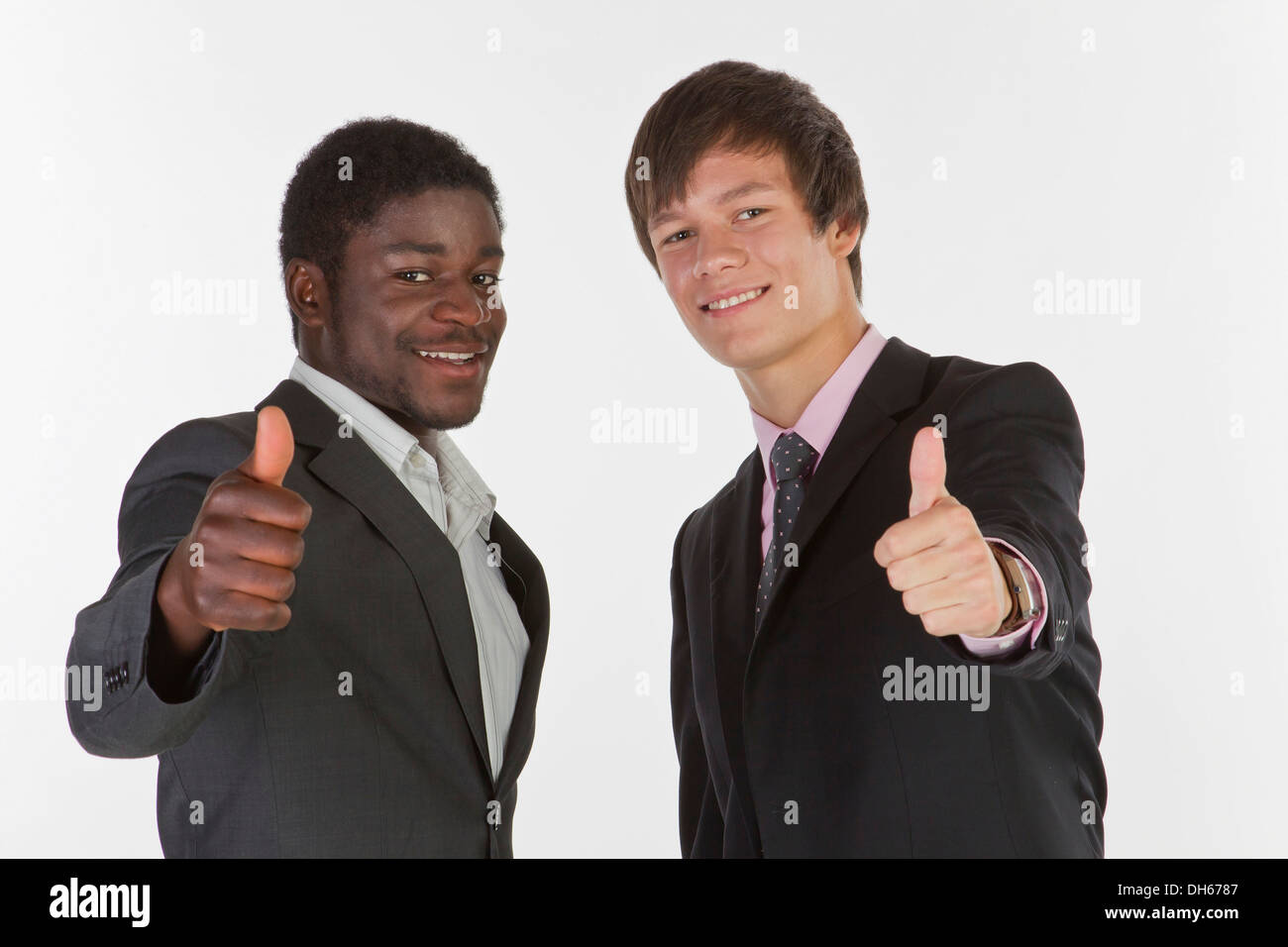 Two young businessmen making a thumbs-up gesture Stock Photo