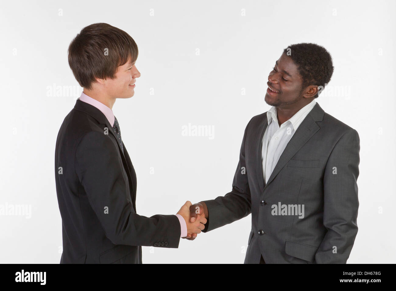 Two young men of different races shaking hands Stock Photo