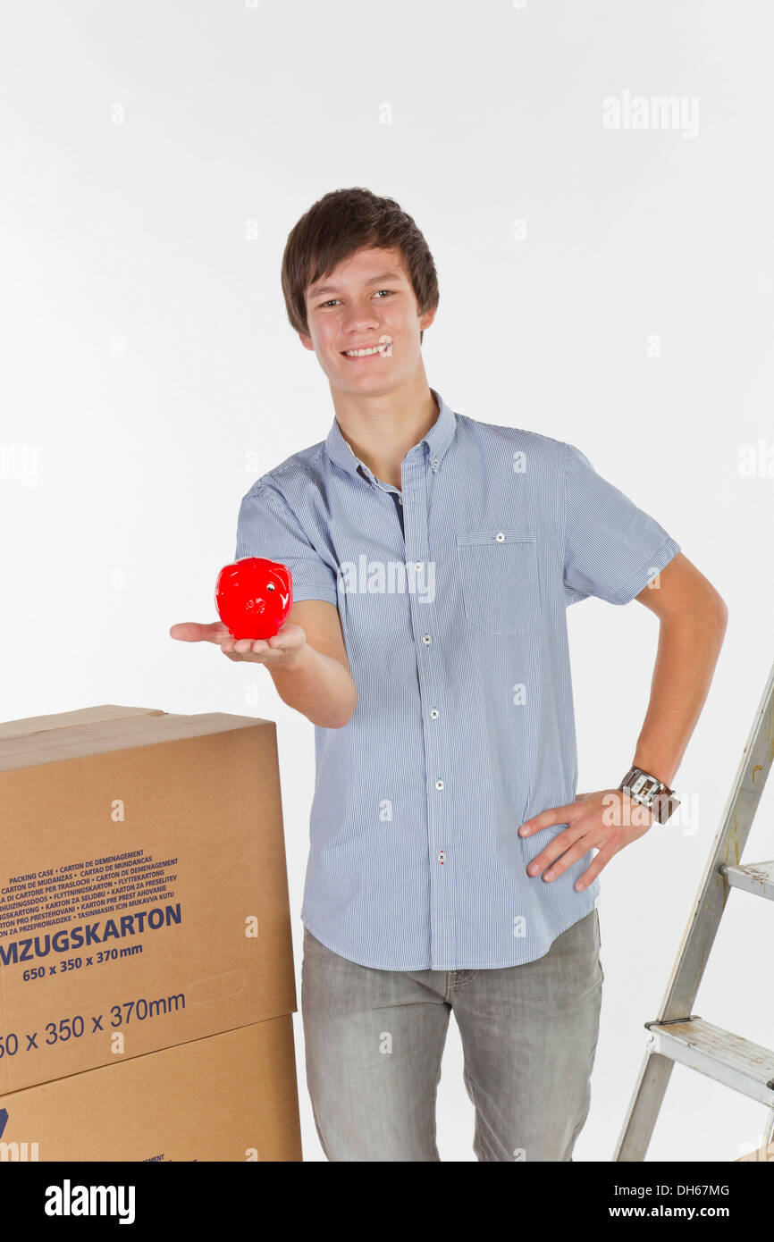 Young man with piggy bank on moving day Stock Photo