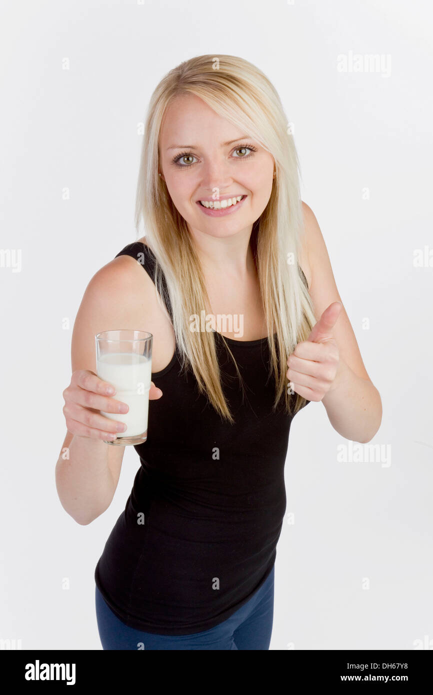 Young blonde woman holding a glass of milk Stock Photo