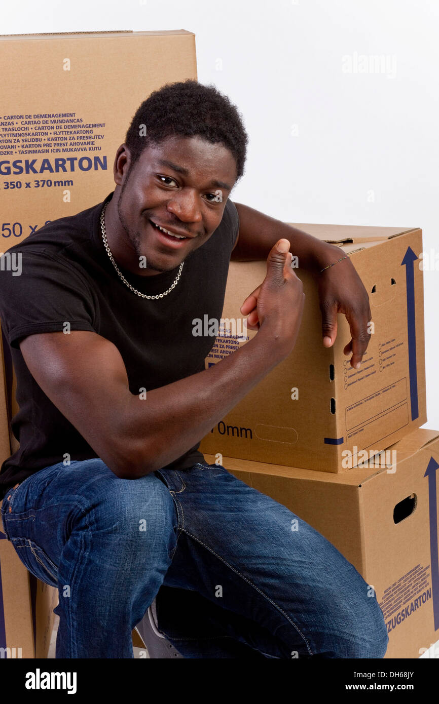 Young black man with moving boxes Stock Photo