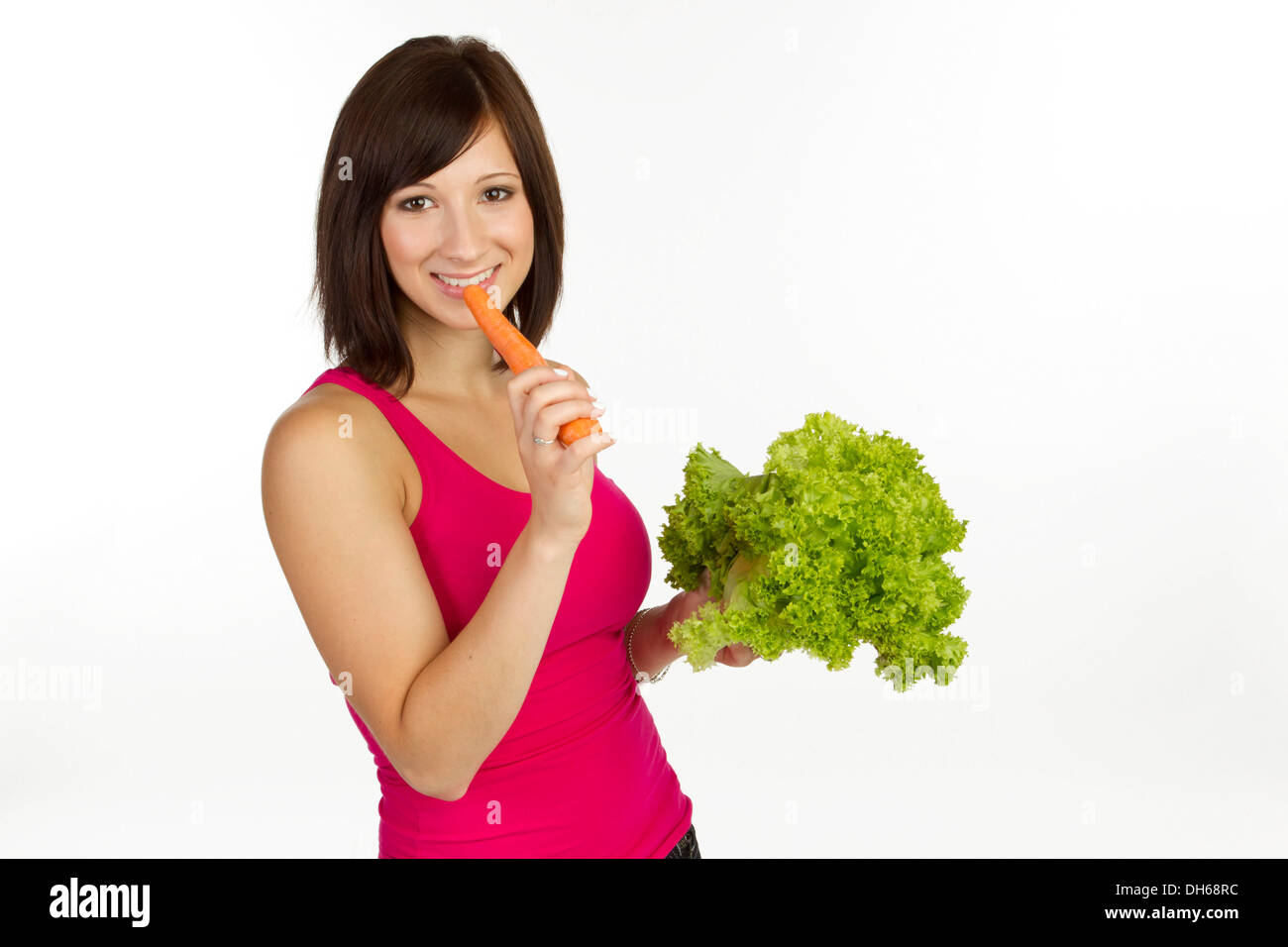 Young woman with carrot and lettuce Stock Photo
