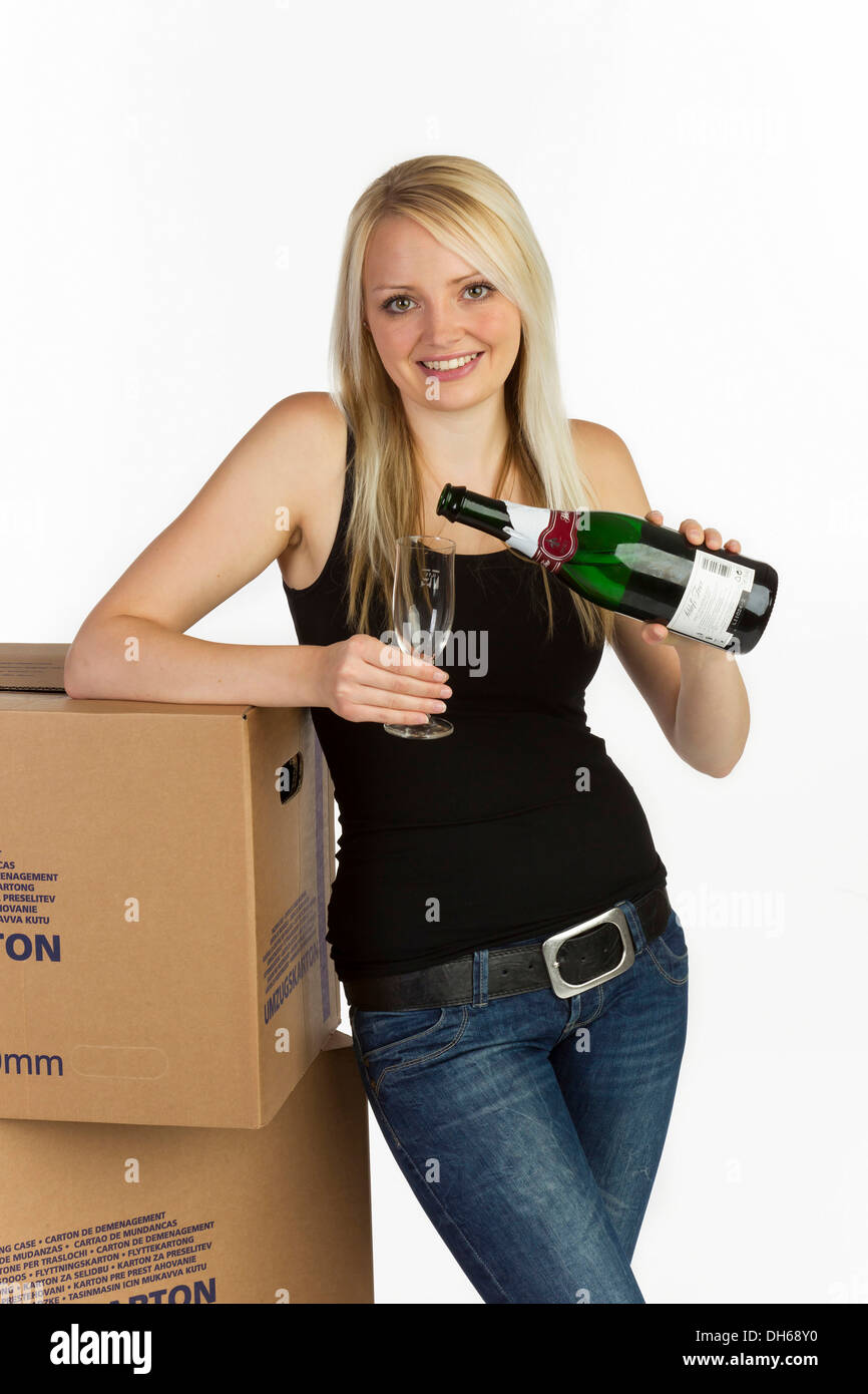 Young woman with moving boxes, bottle and glass of champagne Stock Photo