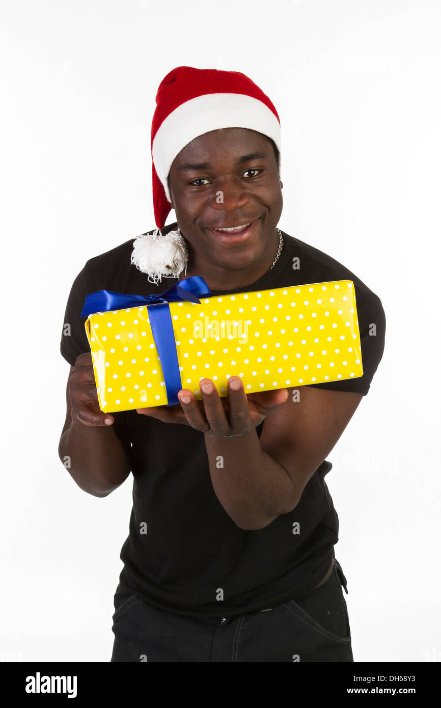 Young black man wearing a Santa hat and holding a present Stock Photo