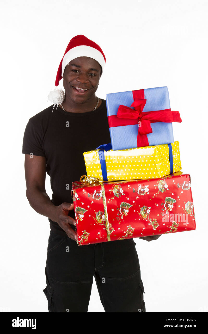 Young black man wearing a Santa hat and holding presents Stock Photo