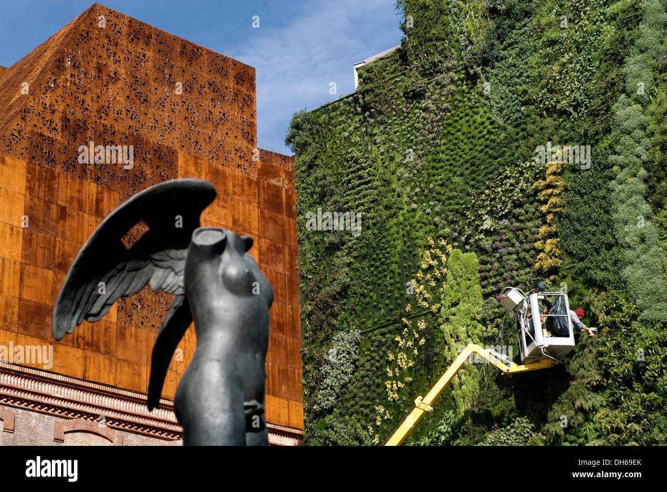 Caixa Forum, by the architects Herzog & de Meuron, with sculpture by sculptor Igor Mitoraj and worker in the vertical garden by Stock Photo