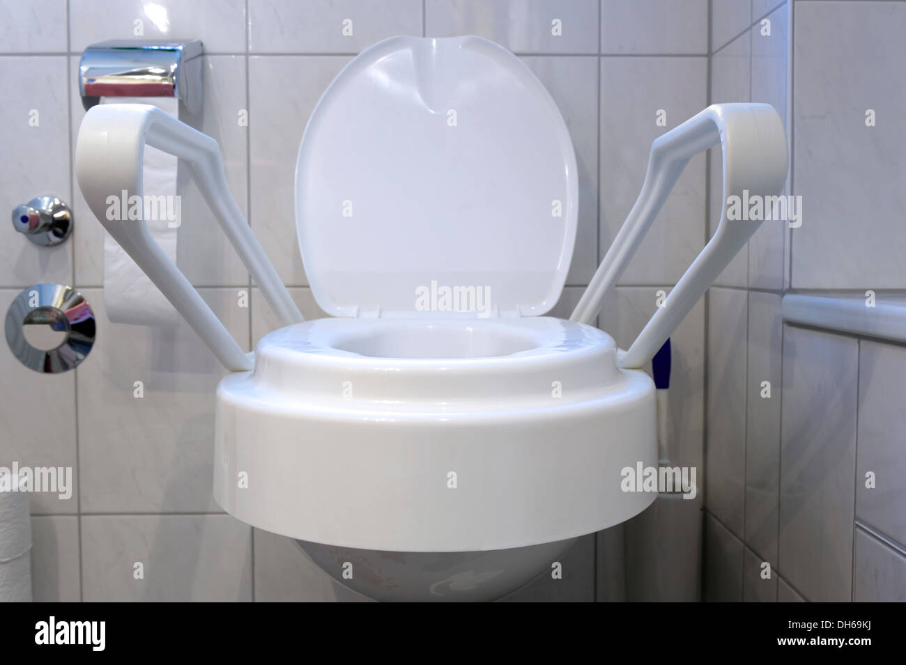 Booster seat for a toilet with two side arms, equipment for home care to care for dependent people in their homes Stock Photo