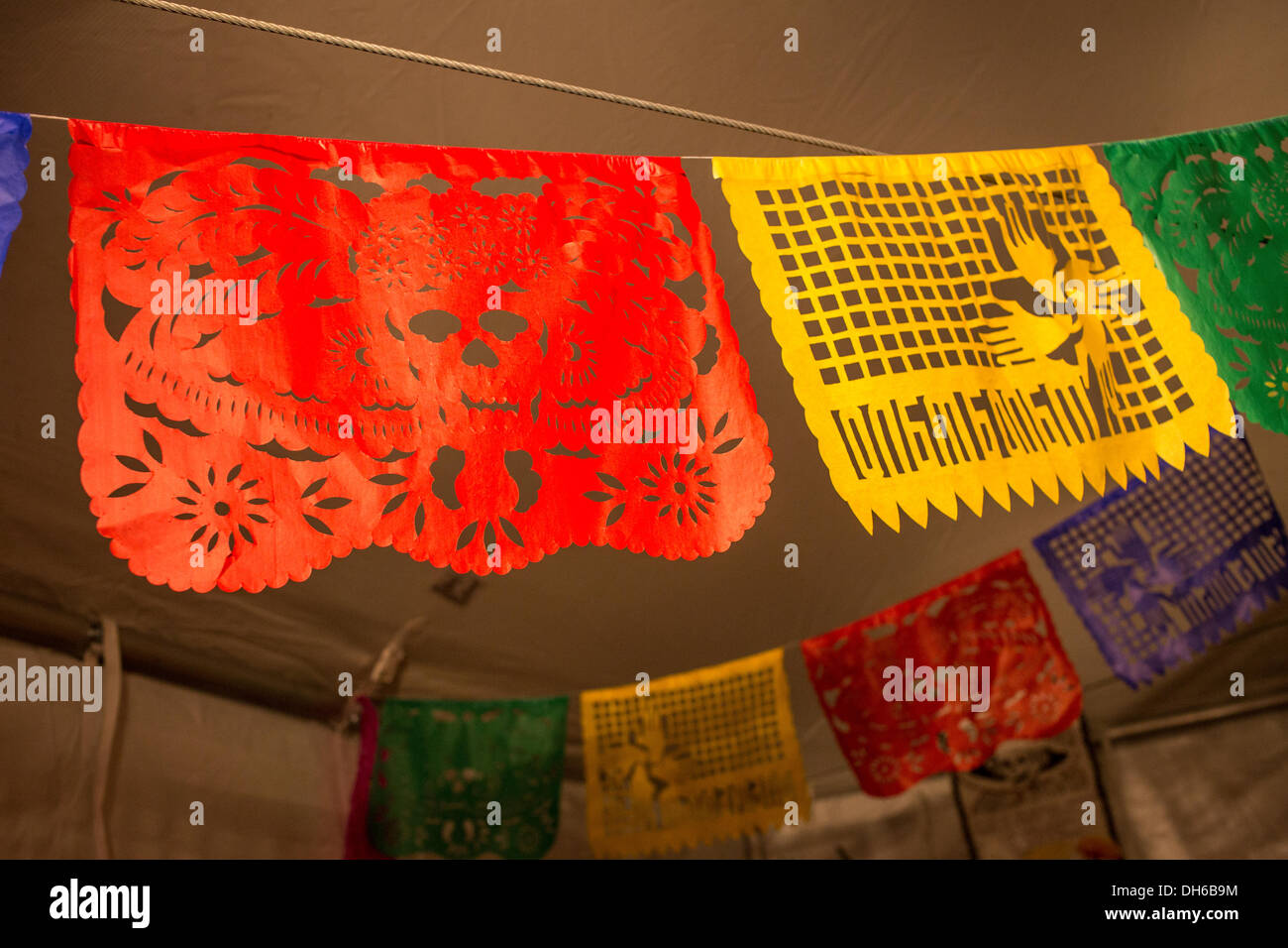 New York, NY, 31 October 2013.. Traditional paper cutout banners, called papel picado, hang from the tent. The red banner depicts a catrina, the skeletal head of a woman wearing an elaborate European-style hat. Credit:  Ed Lefkowicz/Alamy Live News Stock Photo