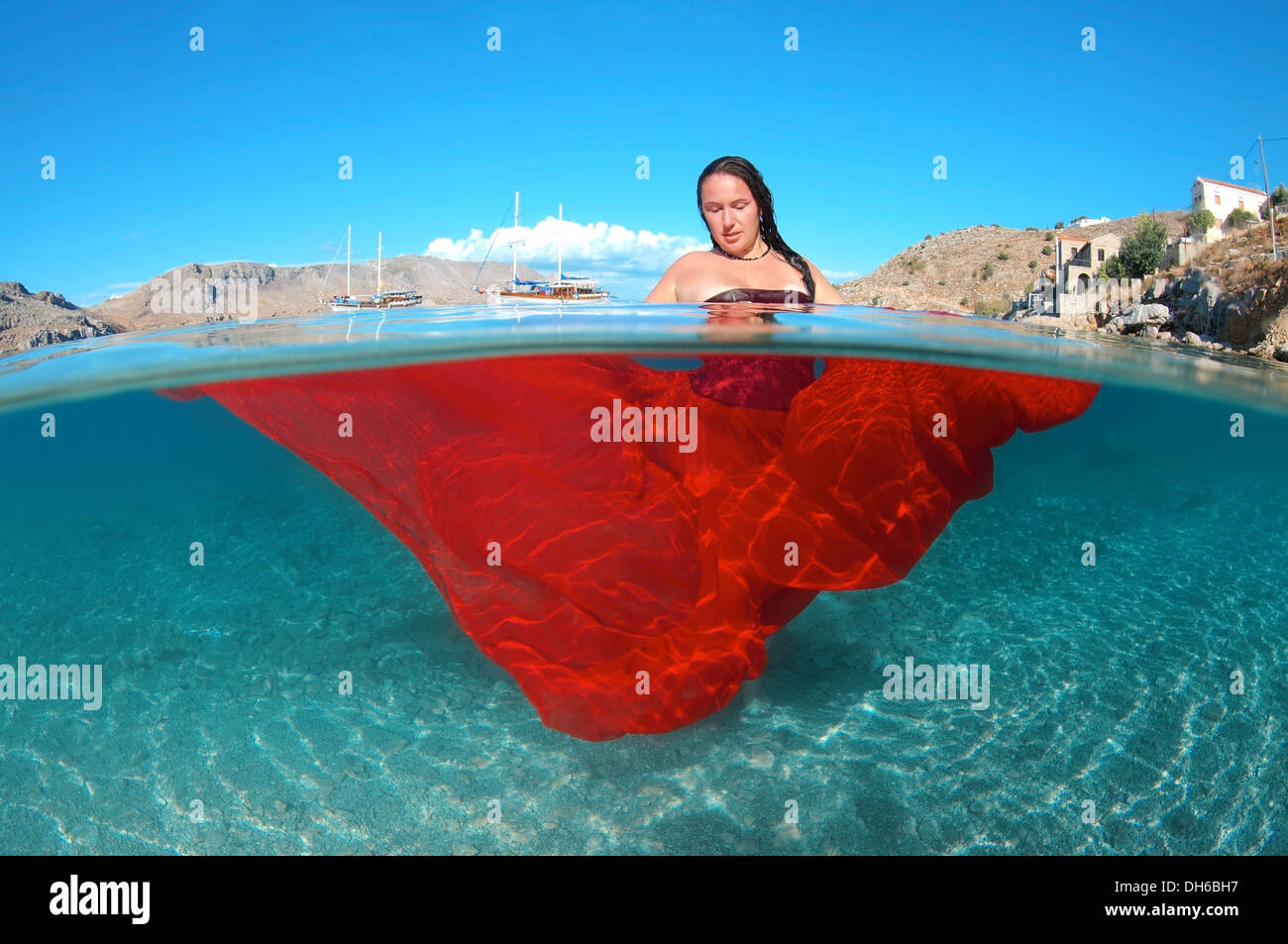 Split level, woman with big hair posing in Aegean Sea underwater ...