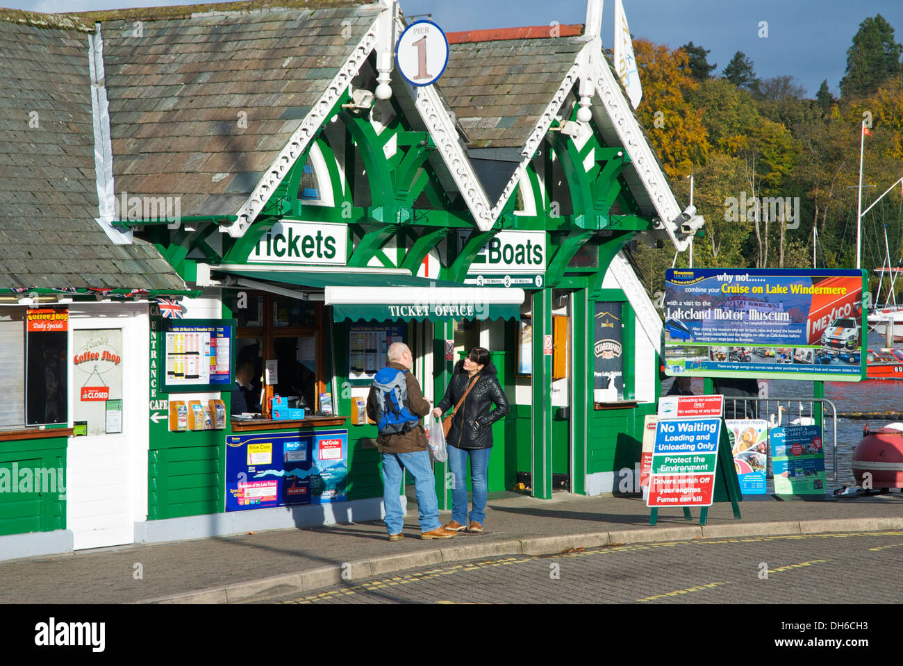 Man & woman at ticket office for Windermere Lake Cruises, Bowness, Lake District National Park
