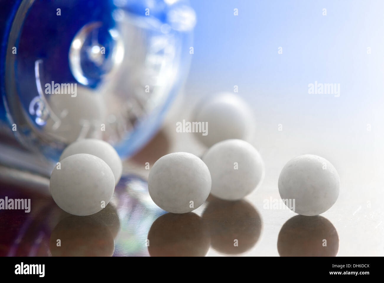 Extreme macro of homeopathic medications - small white balls and the container Stock Photo