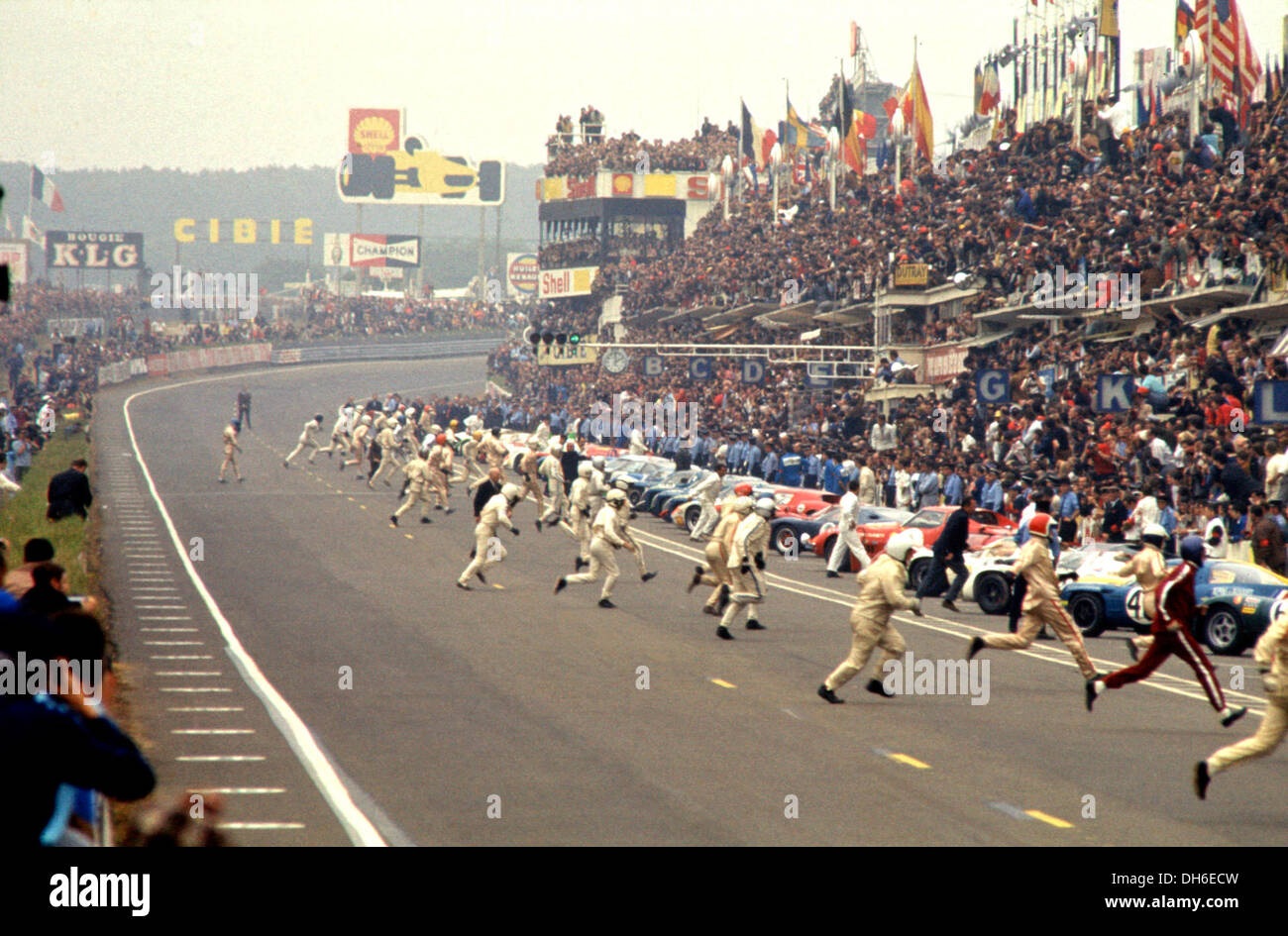 Racing drivers running to their cars at the start of the Le Mans
