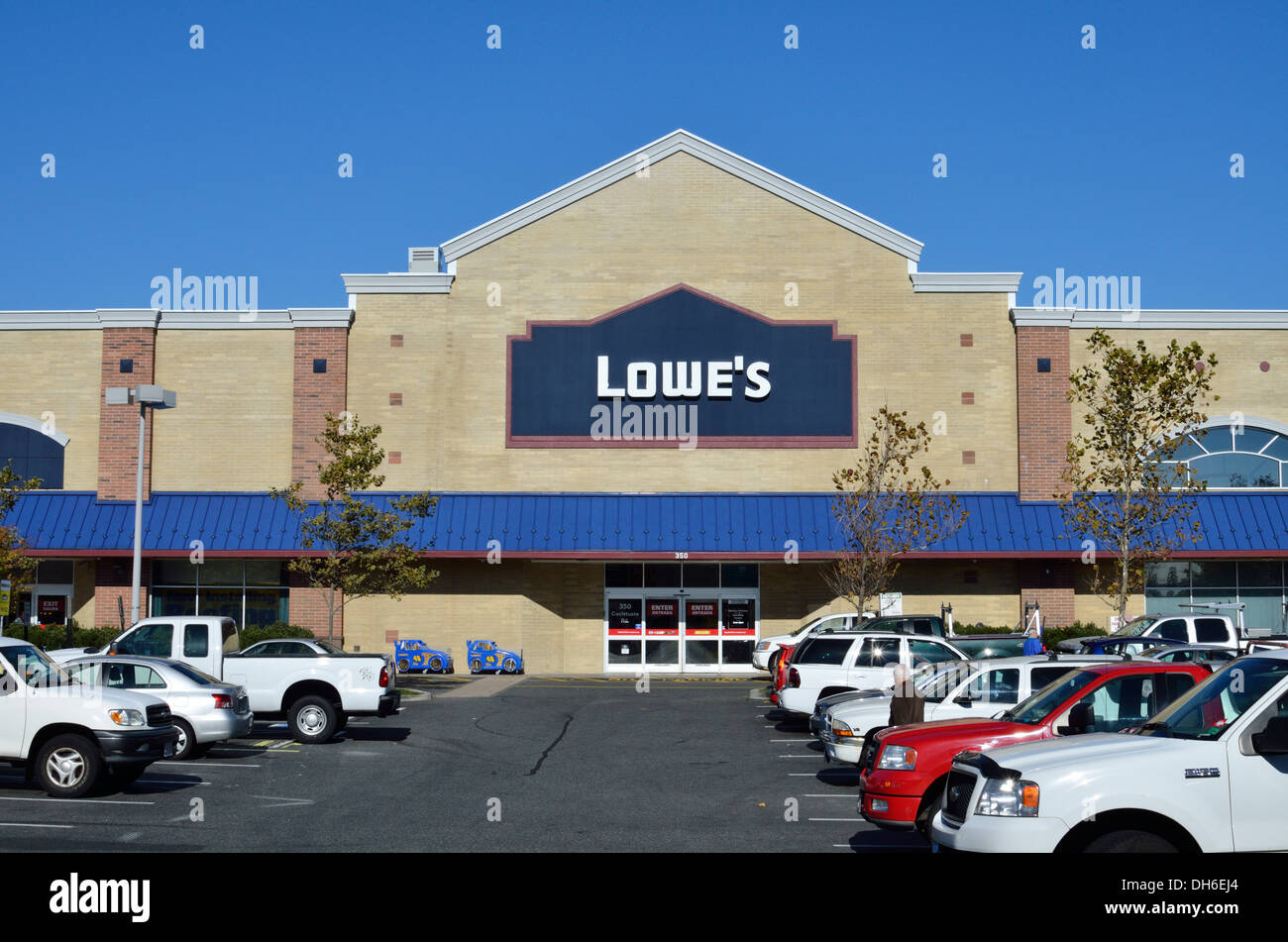Exterior of Lowe's Home Improvement Store on a clear sunny blue sky day with cars & trucks in parking lot. Massachusetts, USA Stock Photo