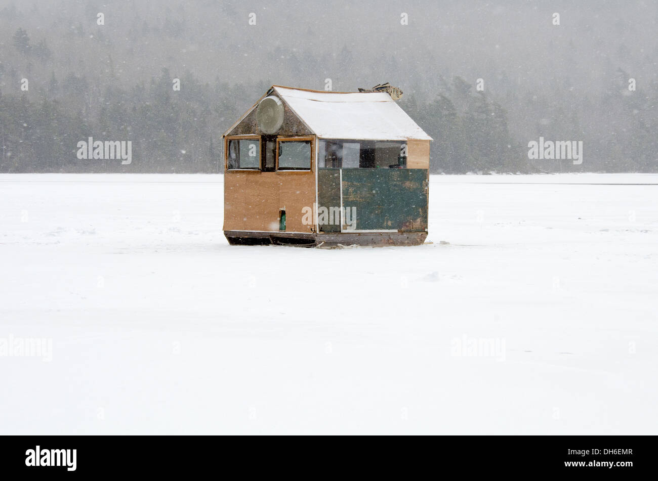 A large green ice fishing shack in a snowstorm. Stock Photo