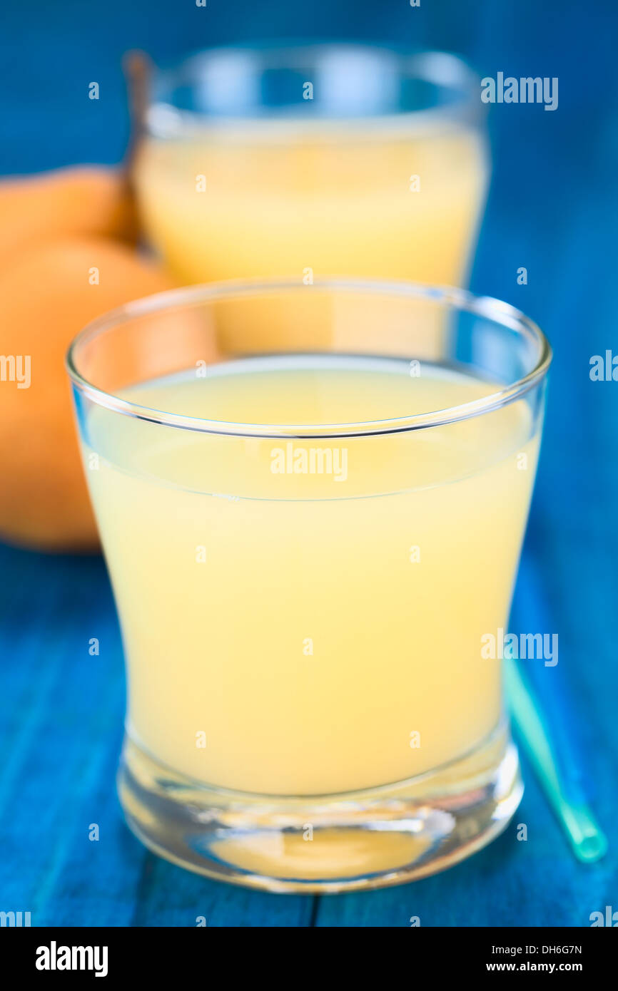 Pear juice in glass with drinking straws on the side and Bosc pear in ...