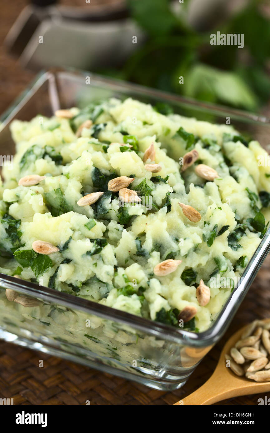 Mashed potatoes with fresh herbs and roasted sunflower seeds in glass bowl Stock Photo