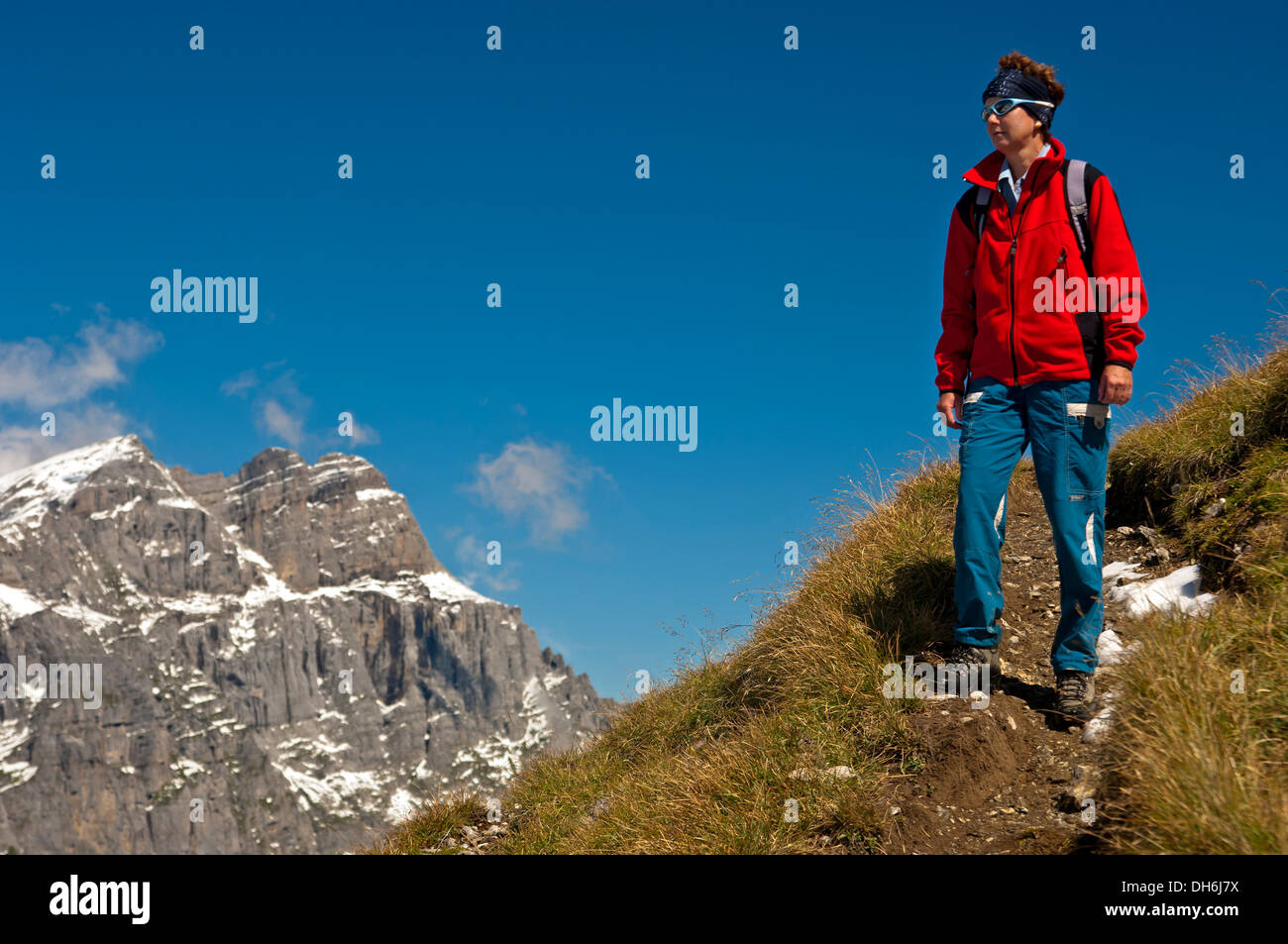 Hiker on a hiking trail in the Glarus Alps near Urnerboden, Swiss Alps, cantone of Uri, Switzerland Stock Photo
