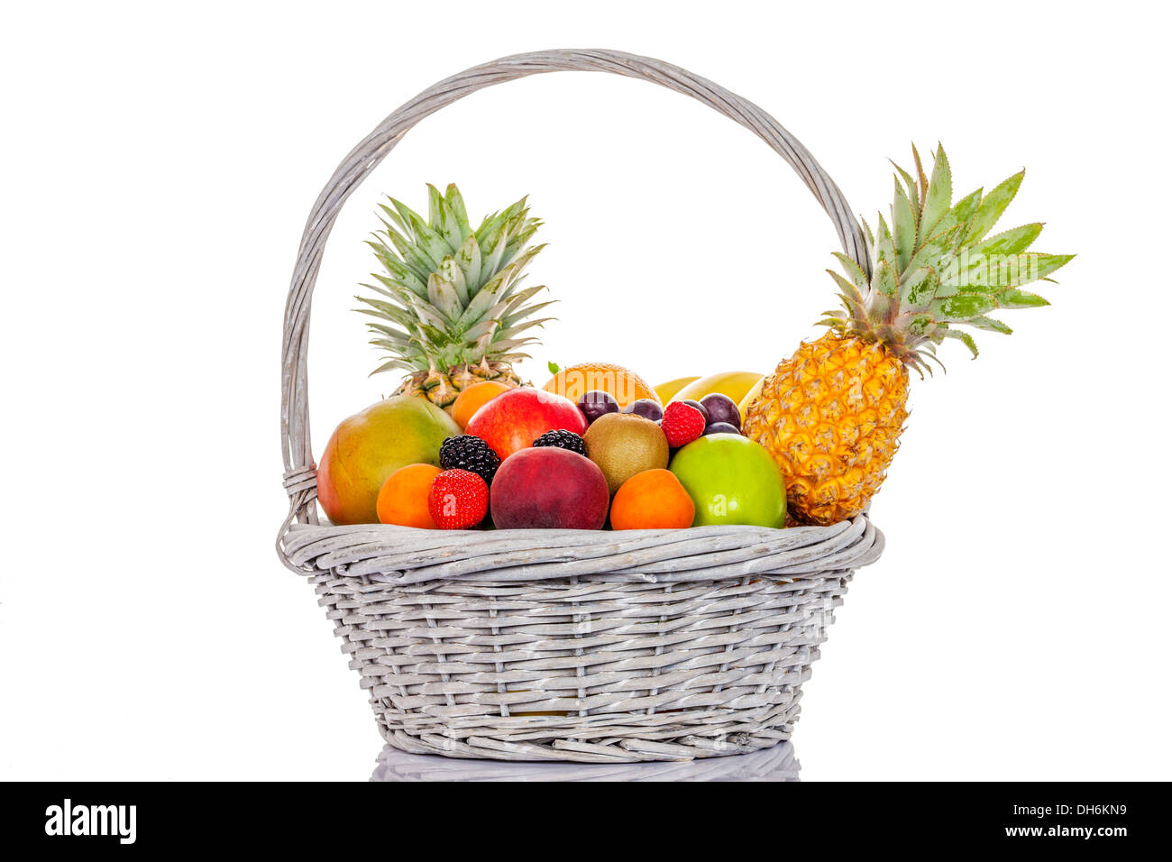 still life of multicoloured fruits in big basket, on white background