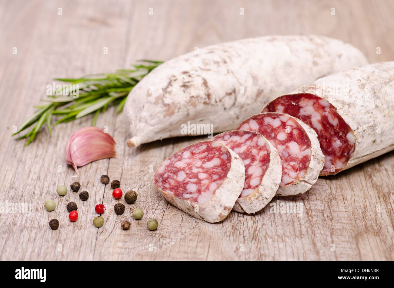Italian air dried salami sausage cacciatore with condiments Stock Photo