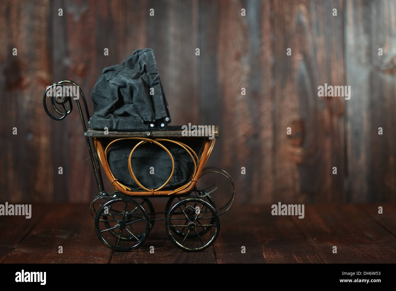 Antique Infant Baby Cradle on Grunge Wooden Background Stock Photo