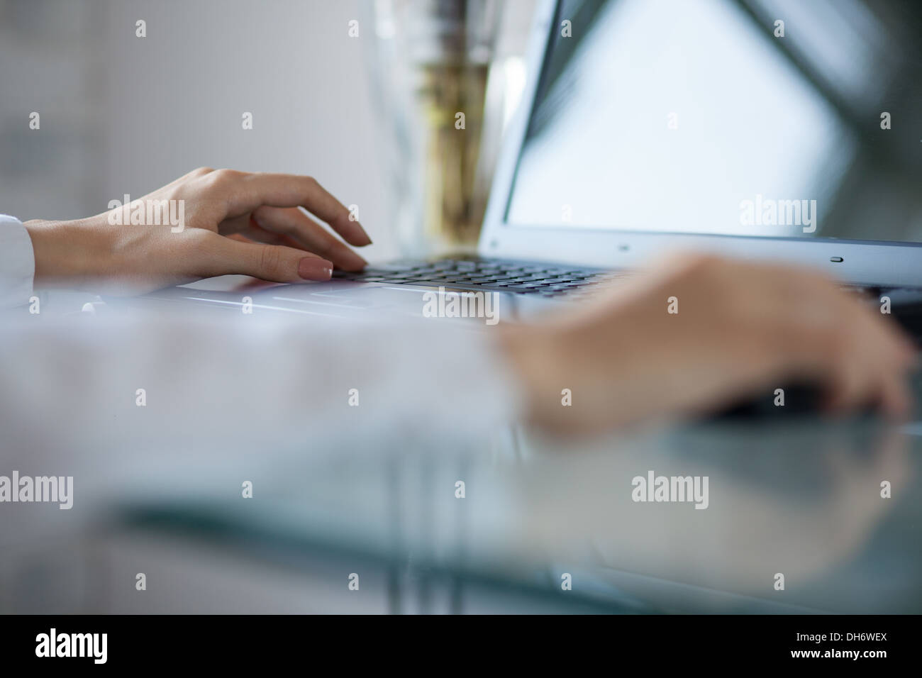 Woman's hand using cordless mouse on glass table Stock Photo Alamy