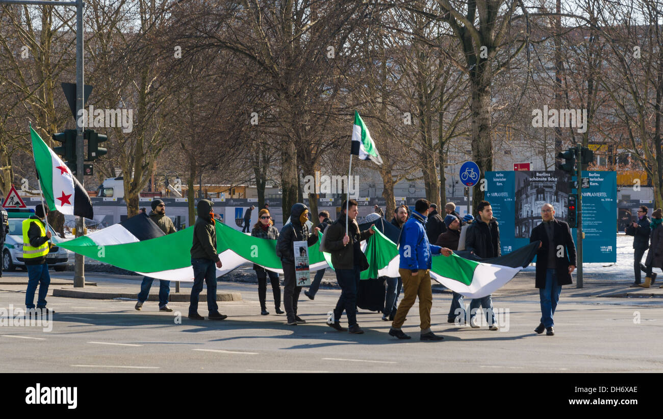 BERLIN - MARCH 16: Pro-opposition protesters activists carrying the Syrian flag on demonstration against ruling regime of Assad Stock Photo