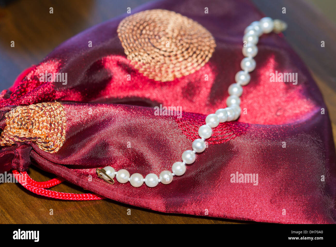 Wedding celebration image with purple velvet jewelry bag and white pearls Stock Photo