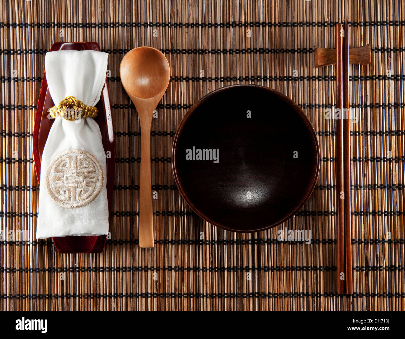 A set of wood eating utensil, spoon, bowl, chopsticks, sushi mat and cloth bag Stock Photo